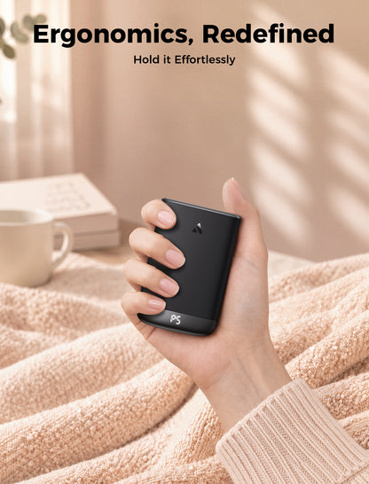 Gray Glow Air hand warmer held comfortably in the palm on a soft blanket at home
